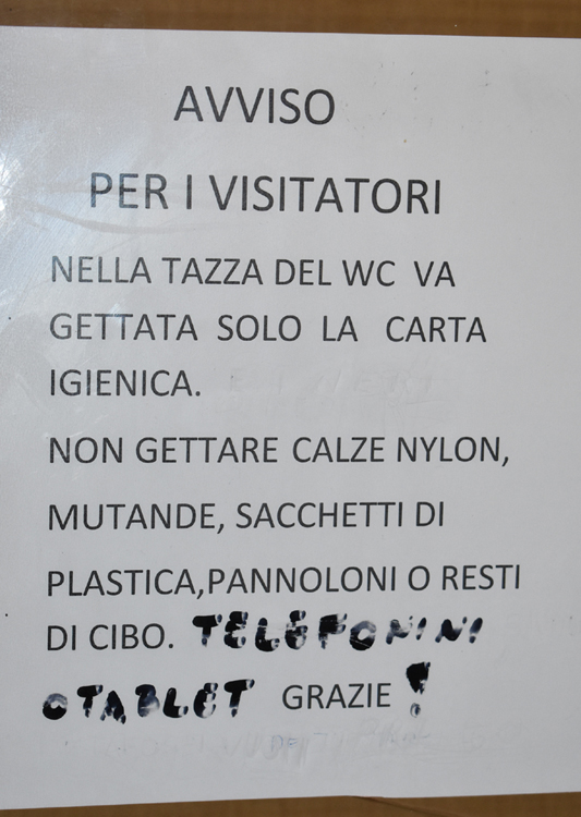 Trieste Cimitero Sant'Anna - graffiti-modified sign in WC